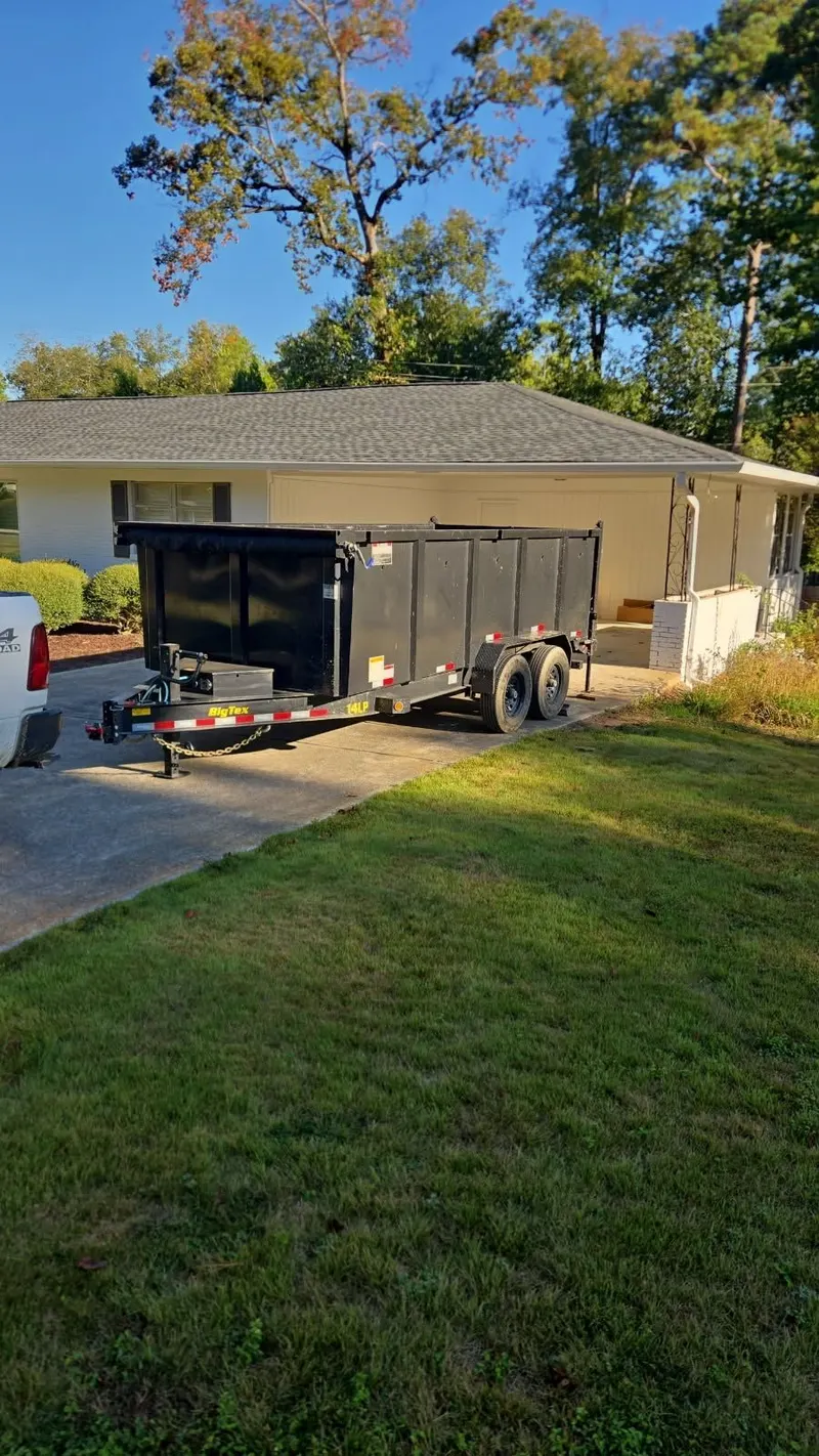 The Racoons dump trailer dropped in a customer’s driveway next to a white house
