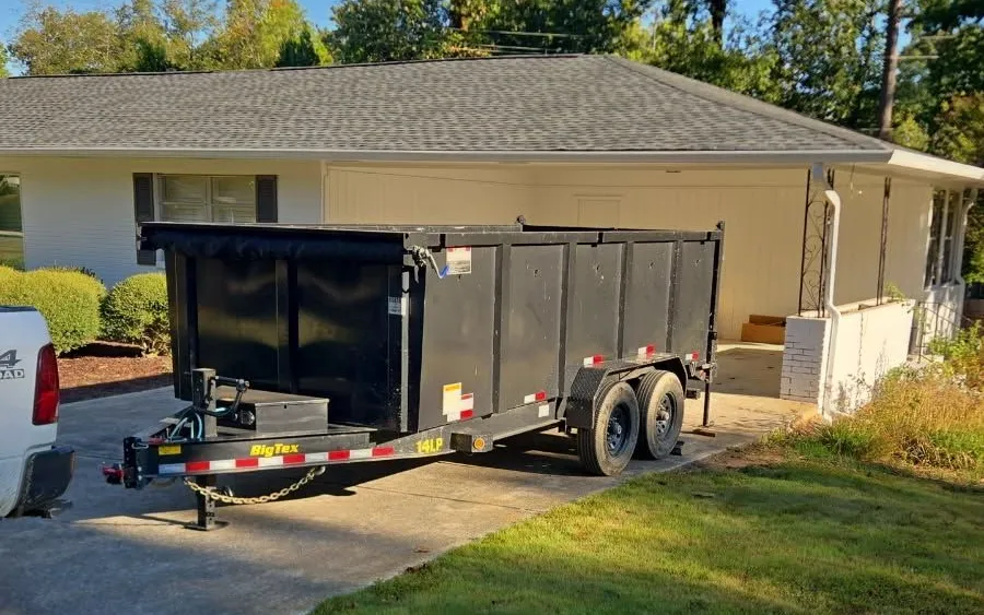 A Racoons dump trailer dropped in a customer’s driveway beside the house