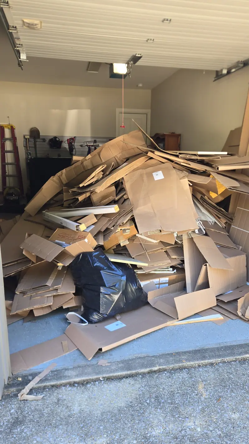 A garage piled with cardboard before a Racoons garage cleanout