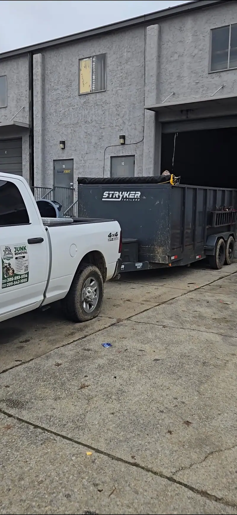 The Racoons pickup and dump trailer behind a commercial building
