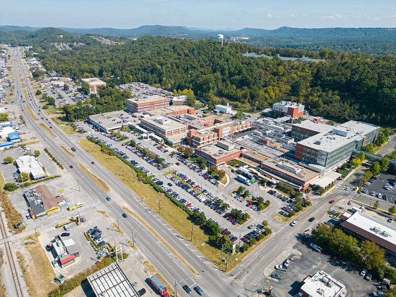 Aerial view of Highway 31 in Alabaster, with shops, a hospital campus and wooded hills beyond