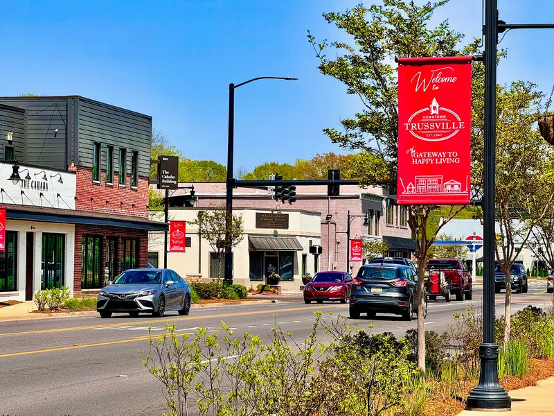 Brick storefronts and a "Welcome to Downtown Trussville" banner on a sunny street